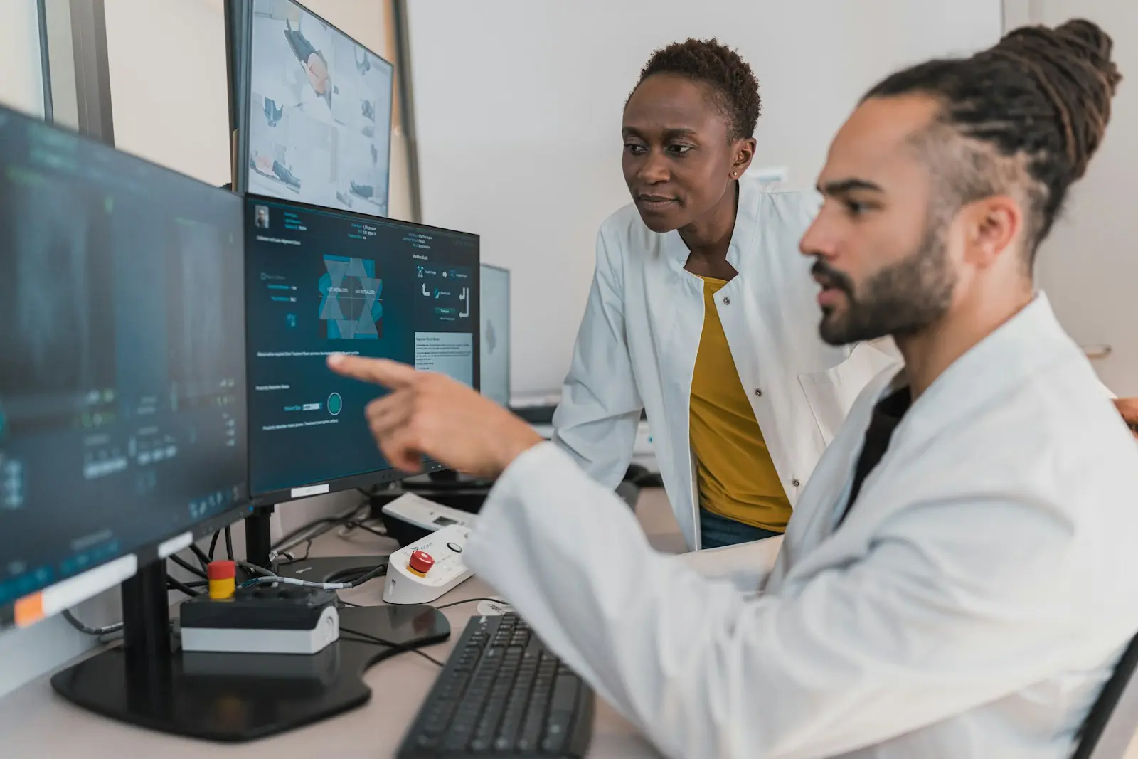 Two clinicians reviewing data on computer screens
